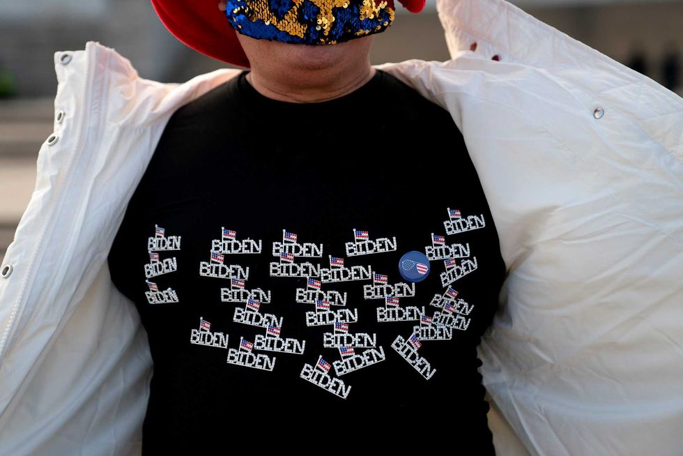 Kyriaki Chris, of Virginia, displays a Biden shirt while standing for a photo near the Lincoln Memorial on January 14, 2021 in Washington, DC. Due to security concerns, the National Mall will be closed on Inauguration Day, as people are encouraged to view inaugural events from their home.