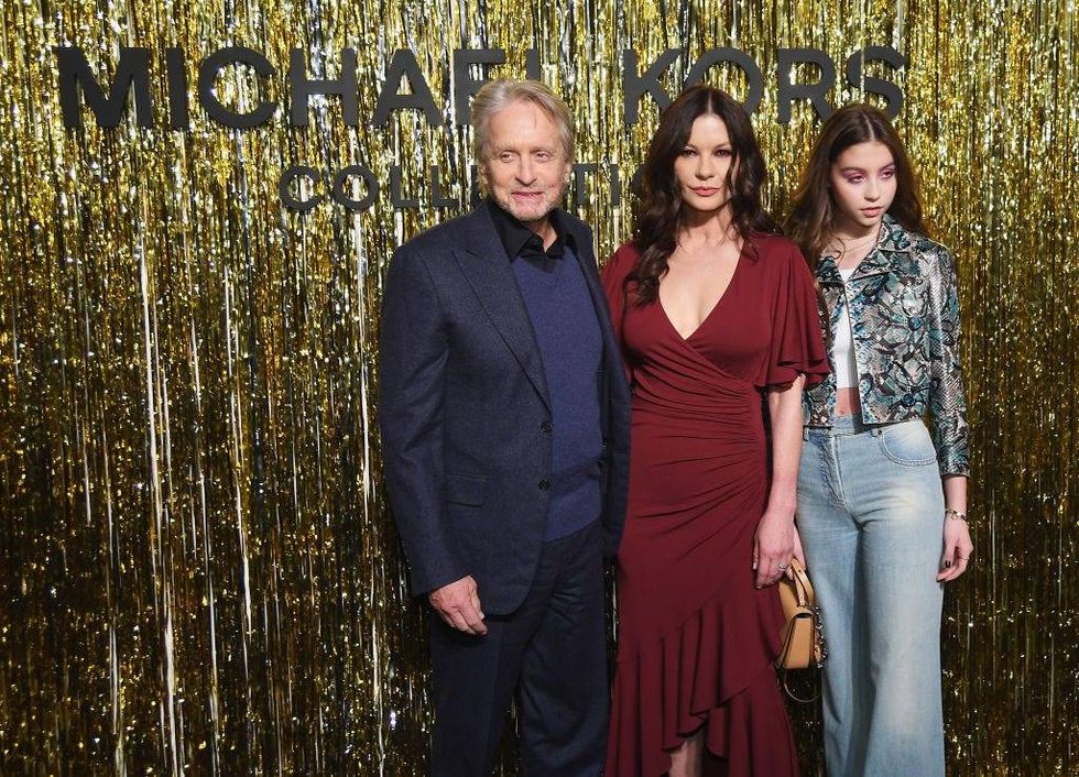 (L-R) Michael Douglas, Catherine Zeta-Jones, and Carys Zeta Douglas attend the Michael Kors Collection Fall 2019 Runway Show at Cipriani Wall Street on February 13, 2019 in New York City.