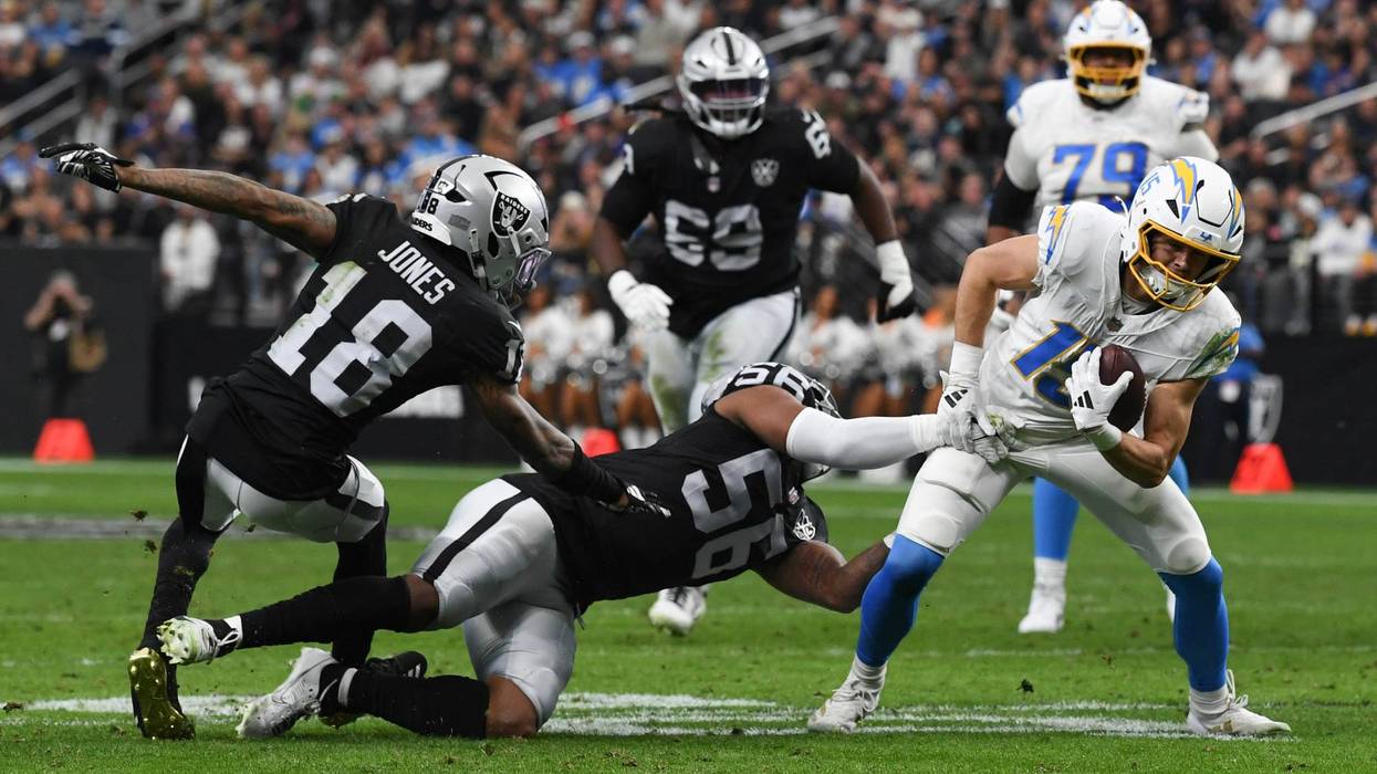 Ladd McConkey #15 of the Los Angeles Chargers breaks a tackle from Jack Jones #18 and Amari Burney #56 of the Las Vegas Raiders in the first quarter of their game at Allegiant Stadium on January 05, 2025 in Las Vegas, Nevada.