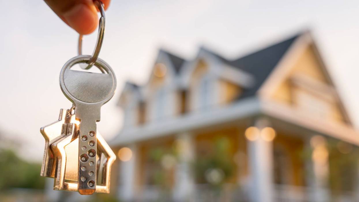 Landlord key for unlocking house is plugged into the door. Second hand house for rent and sale. keychain is blowing in the wind. mortgage for new home, buy, sell, renovate, investment, owner, estate