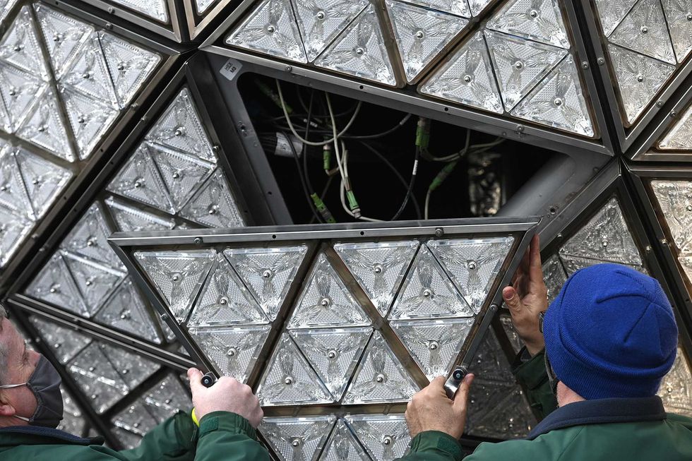 Landmark electricians Chris Sisti and Nick Bonavita demonstrate the installation of a Waterford crystal panel onto the Times Square New Year