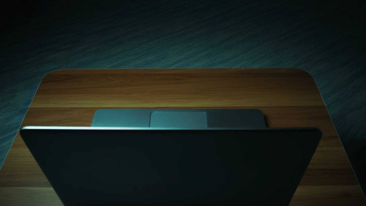 Laptop on a table in a dark room.