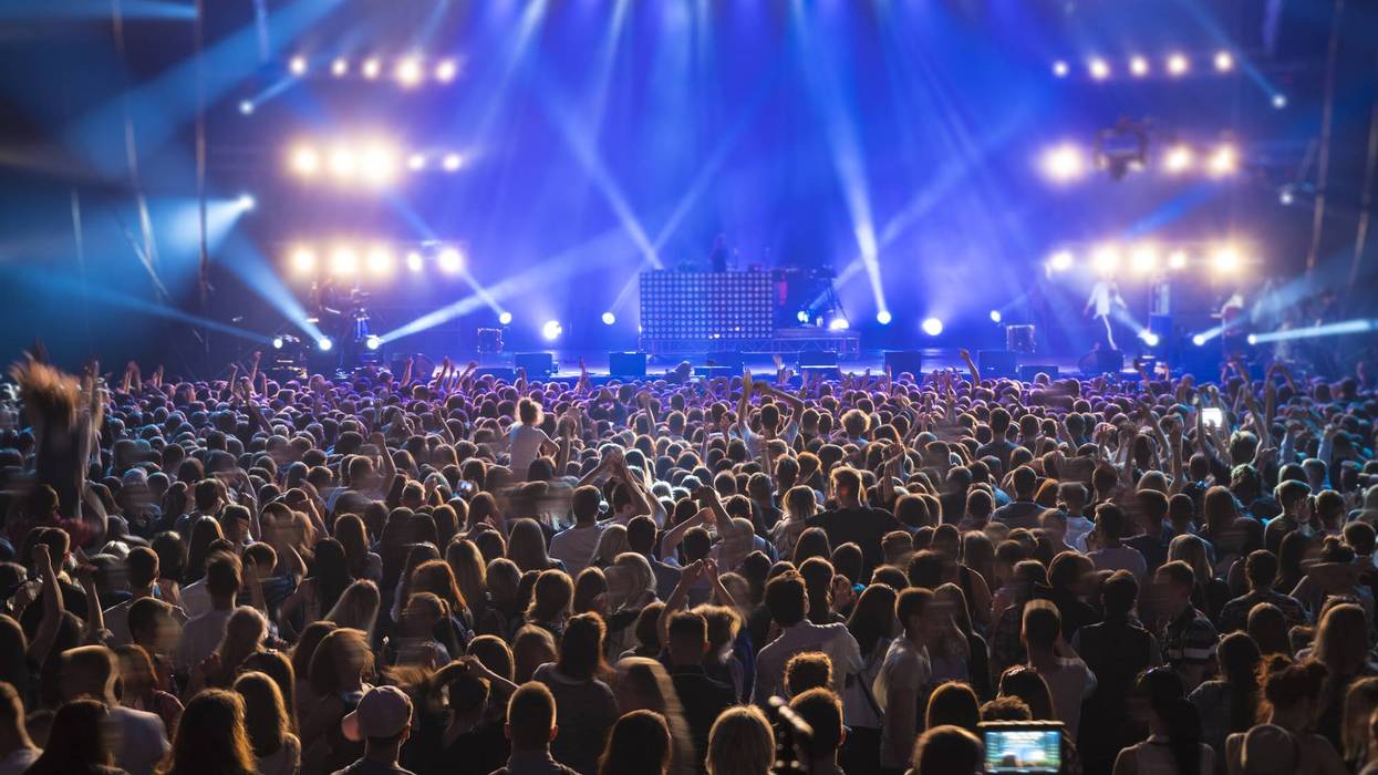 Large Crowd of Fans at Live Music Concert with Vibrant Blue Stage Lights