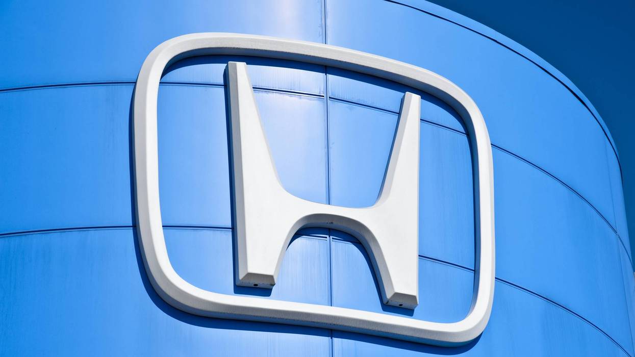 Large white Honda logo on a curved blue building.