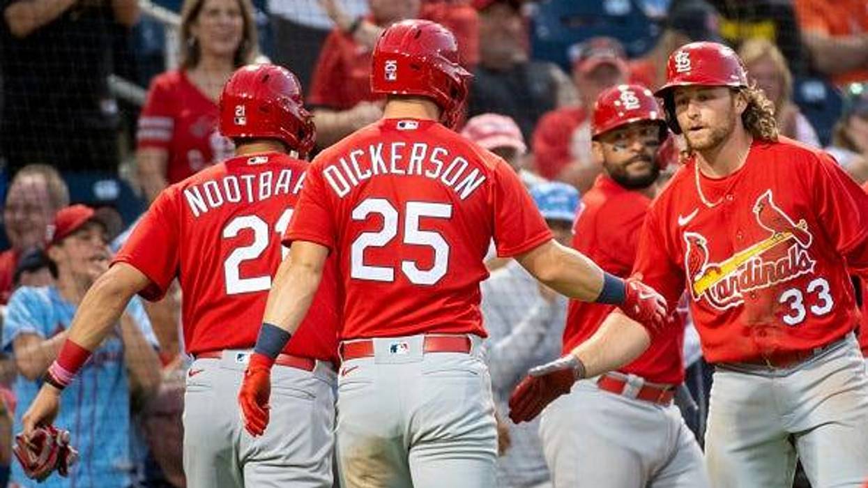 Lars Nootbaar (21), Corey Dickerson (25), and Juan Yepez (center) celebrate with Brendan Donovan (33) during an MLB spring training game against the Washington Nationals.