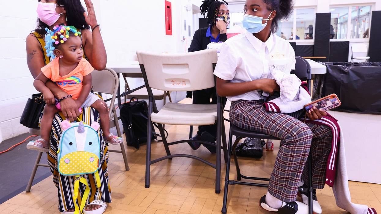 LaToya Feltus sits with her three daughters after the elder two both received a COVID-19 vaccination.