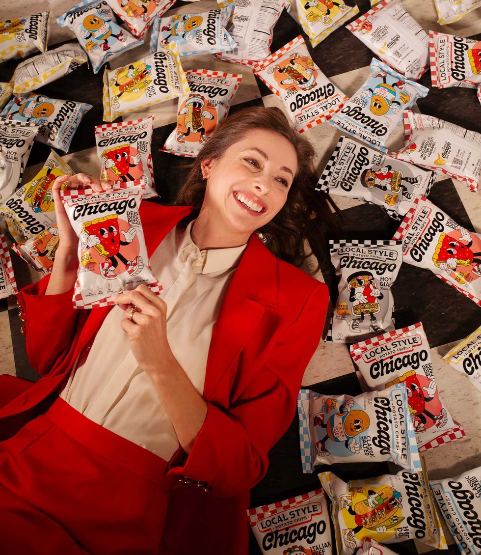 Laura Gardner poses with bags of Local Style Potato Chips. They launched on April 3, 2025.