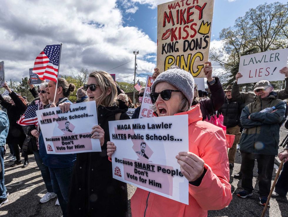 Lauren Healy of Nanuet, left, and Ellen Skelly-Hughes of Pearl River were among the approximately 100 people who protested outside Clarkstown South High School in New City before Rep. Mike Lawler held a town hall inside the school April 27, 2025