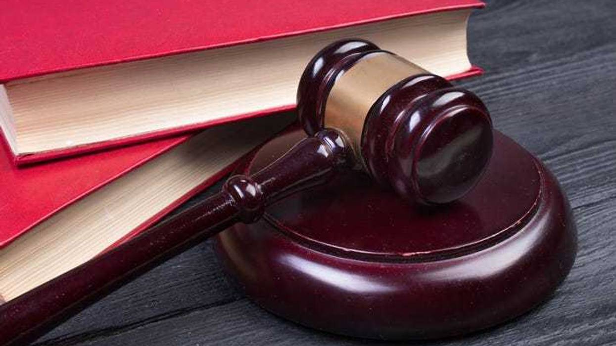 Law concept - Open law book with a wooden judges gavel on table in a courtroom or law enforcement office on blue background. Copy space for text