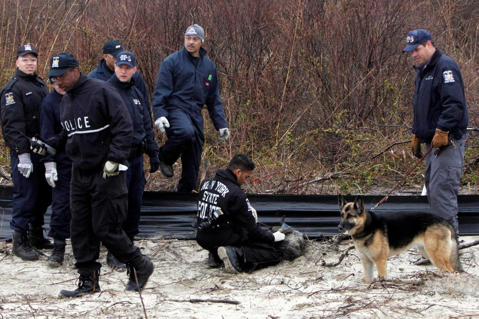 Law enforcement and emergency personnel examine an object on the side of the road, center, near Jones Beach on April 11, 2011, in Wantagh, N.Y.