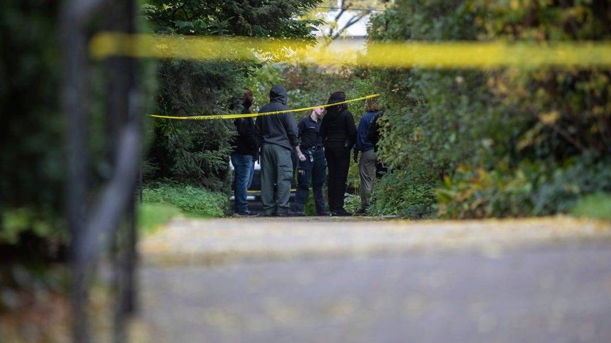 Law enforcement officers stand near the scene where a Detroit synagogue president, Samantha Woll