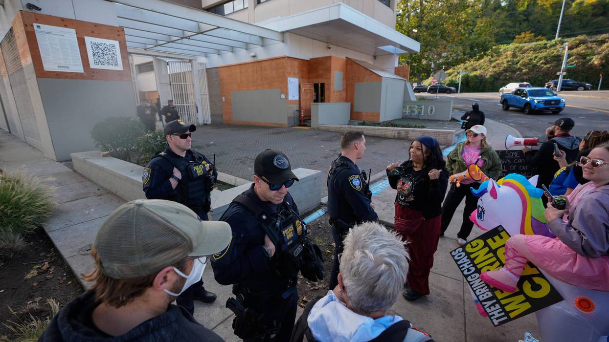Law enforcement officers talk with protesters outside a United States Immigration and Customs Enforcement (ICE) facility in Portland, Ore., Monday, Oct. 20, 2025.