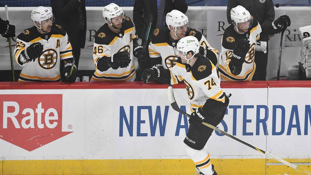 left wing Jake DeBrusk (74) is congratulated by teammates after scoring