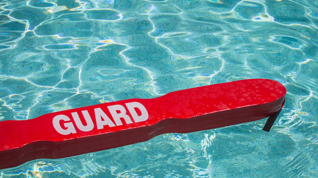 Lifeguard's red rescue tube floating in a pool