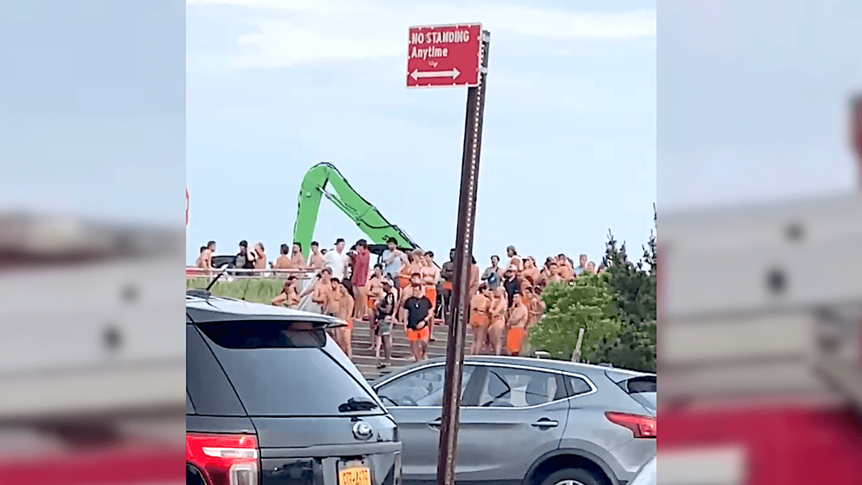 Lifeguards and beachgoers watch as a boy is taken away in an ambulance on Sunday evening