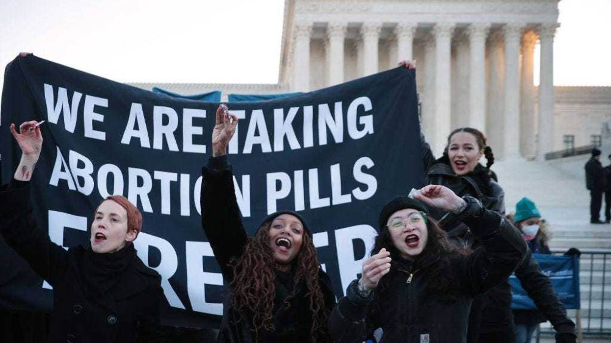 Lila Bonow, Alana Edmondson and Aiyana Knauer prepare to take abortion pill while demonstrating in front of the U.S. Supreme Court as the justices hear hear arguments in Dobbs v. Jackson Women's Health, a case about a Mississippi law that bans most abortions after 15 weeks, on December 01, 2021 in Washington, DC. With the addition of conservative justices to the court by former President Donald Trump, experts believe this could be the most important abortion case in decades and could undermine or overturn Roe v. Wade. (Photo by Chip Somodevilla/Getty Images)