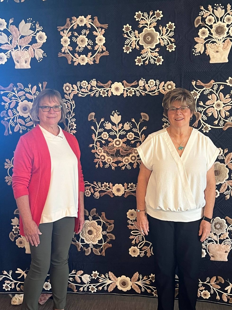 Linda Chiu (left) and Pam Hadfield (right) in front of a quilt