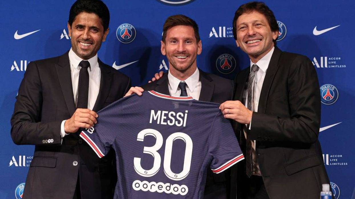 Lionel Messi poses with his jersey next to President Nasser Al Khelaifi and Leonardo after the press conference of Paris Saint-Germain at Parc des Princes on August 11, 2021 in Paris, France