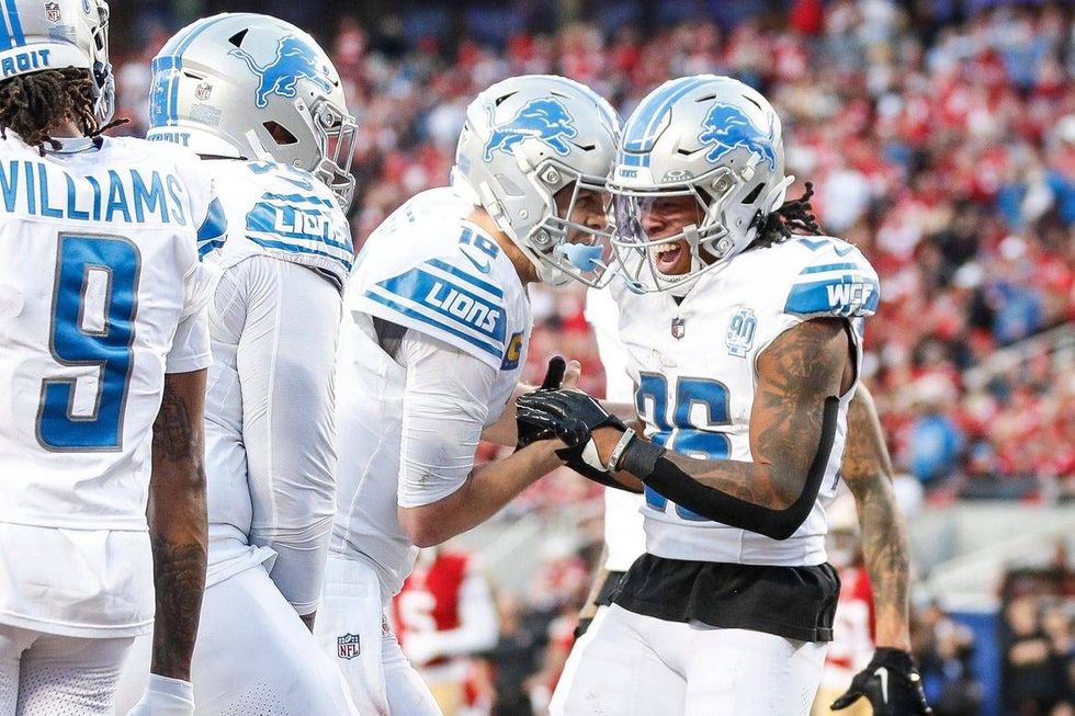 Lions running back Jahmyr Gibbs, right, celebrates a touchdown against 49ers with quarterback Jared Goff during the first half of the NFC championship game at Levi