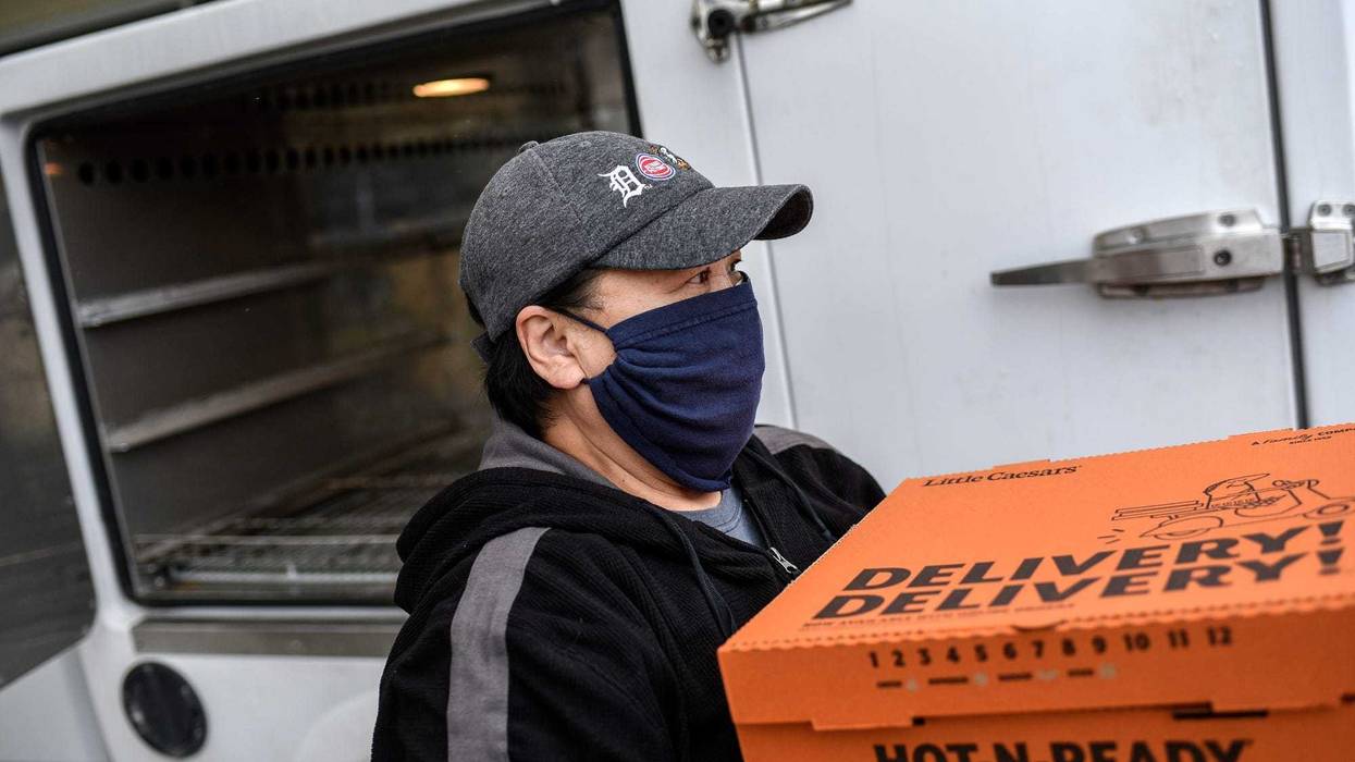 Little Caesars Pizza delivery driver carrying boxes