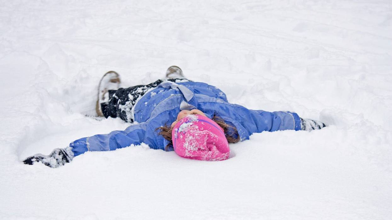 Little Girl having fun making a Snow Angel in the First Snowfall of the Year