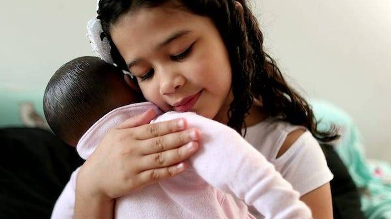Little girl hugging doll