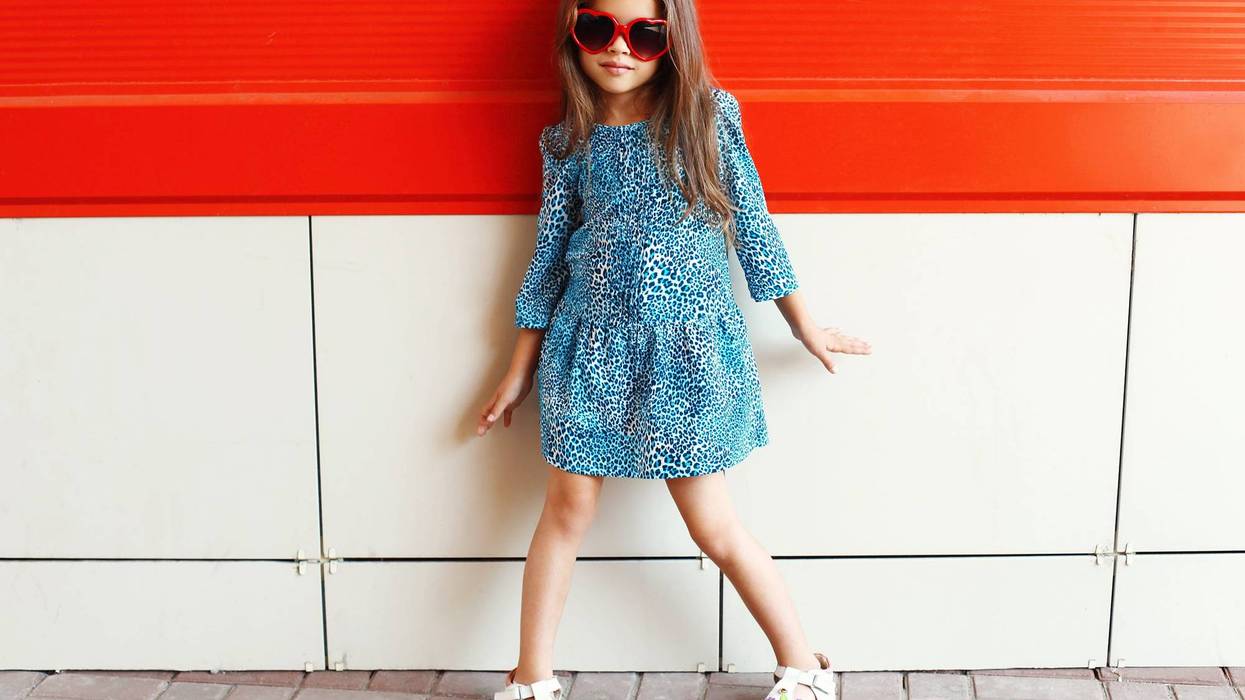 little girl wearing a leopard dress and sunglass