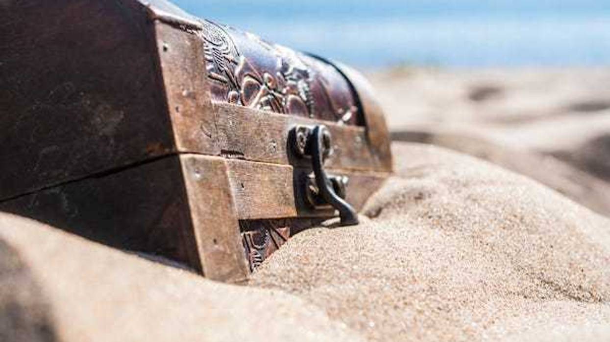 Locked chest, buried treasure on a beach