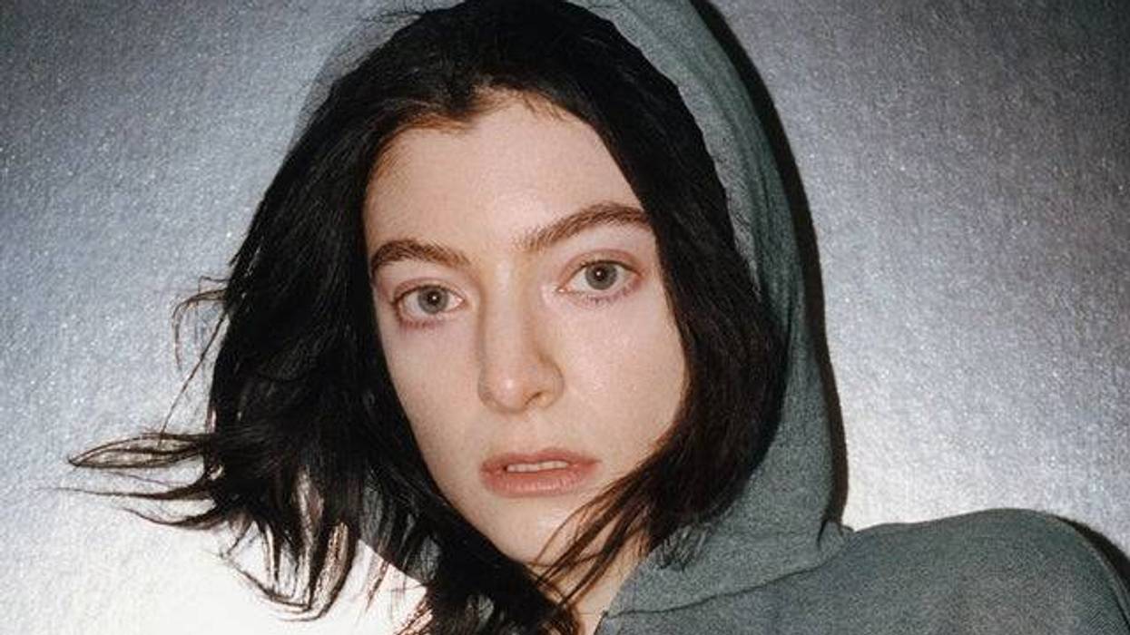 Lorde in a grey hoodie, looking directly at the camera.
