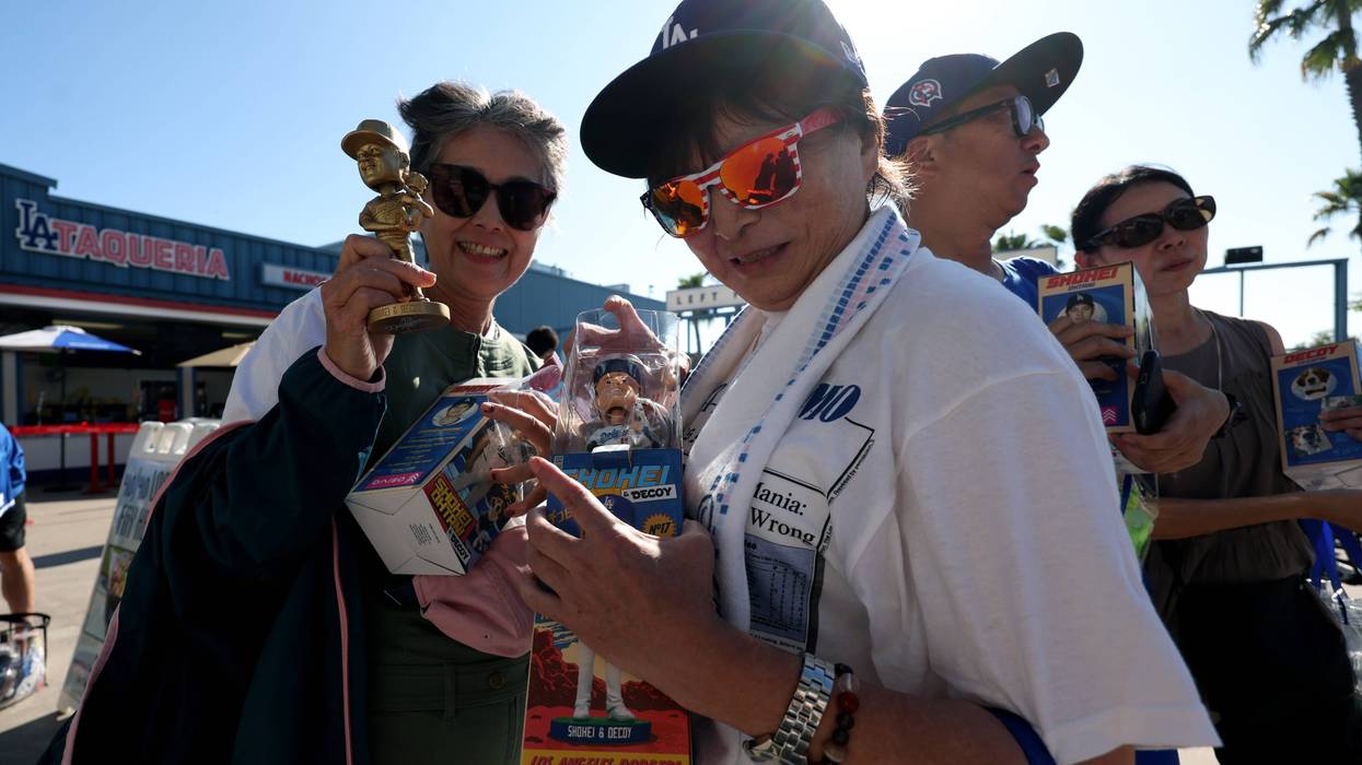 LOS ANGELES, CALIFORNIA - AUGUST 28: Fans pose with their Shohei Ohtani #17 of the Los Angeles Dodgers bobblehead before the game against the Baltimore Orioles at Dodger Stadium on August 28, 2024 in Los Angeles, California.