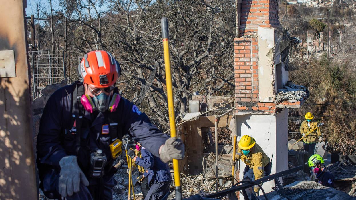 LOS ANGELES, CALIFORNIA - JANUARY 16: Los Angeles Fire Fighters and Sacramento Fire Fighters Urban Search & Rescue team inspect a burned house from the Palisades Fire in the Pacific Palisades neighborhood on January 16, 2025 in Los Angeles, California. Wildfires fueled by intense Santa Ana Winds have burned across thousands of acres in Los Angeles County causing incredible damage and deaths but firefighters have made significant containment as the weather has subsided.