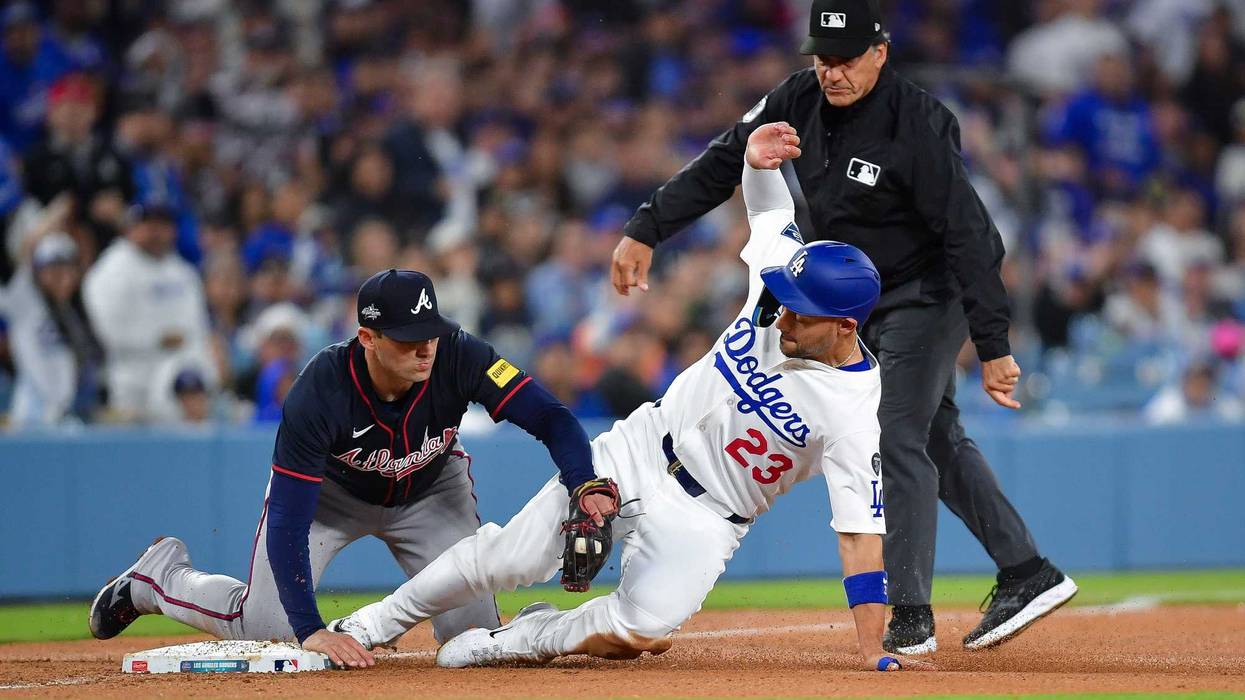 Los Angeles Dodgers outfielder Michael Conforto (23) is out at third against Atlanta Braves third baseman Austin Riley (27) during the sixth inning at Dodger Stadium.
