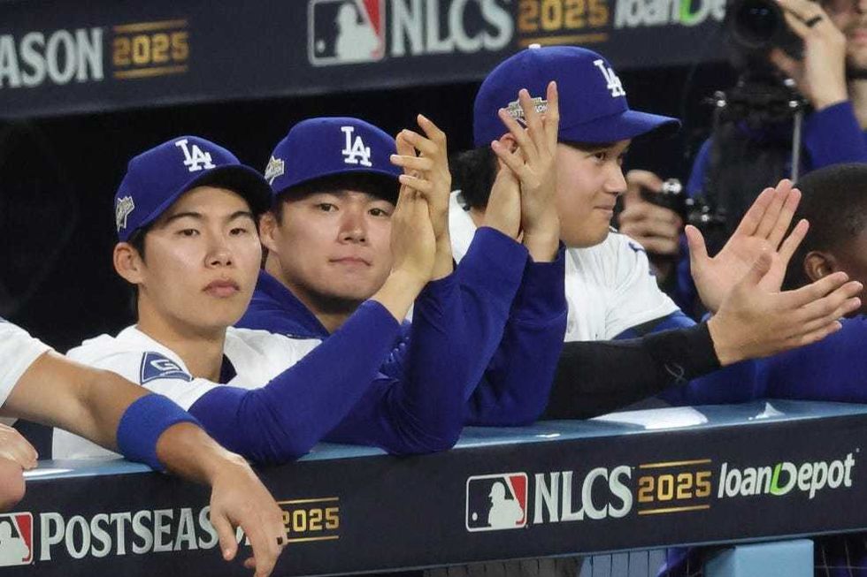 Los Angeles Dodgers second baseman Hyeseong Kim (6), pitcher Yoshinobu Yamamoto (18), and two-way player Shohei Ohtani (17) watch the game from the dugout in the ninth inning against the Milwaukee Brewers in game four of the NLCS round for the 2025 MLB playoffs at Dodger Stadium.