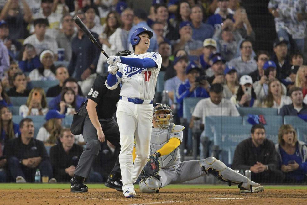Los Angeles Dodgers two-way player Shohei Ohtani (17) hits a solo home run against the Milwaukee Brewers during the seventh inning of game four of the NLCS round for the 2025 MLB playoffs at Dodger Stadium.