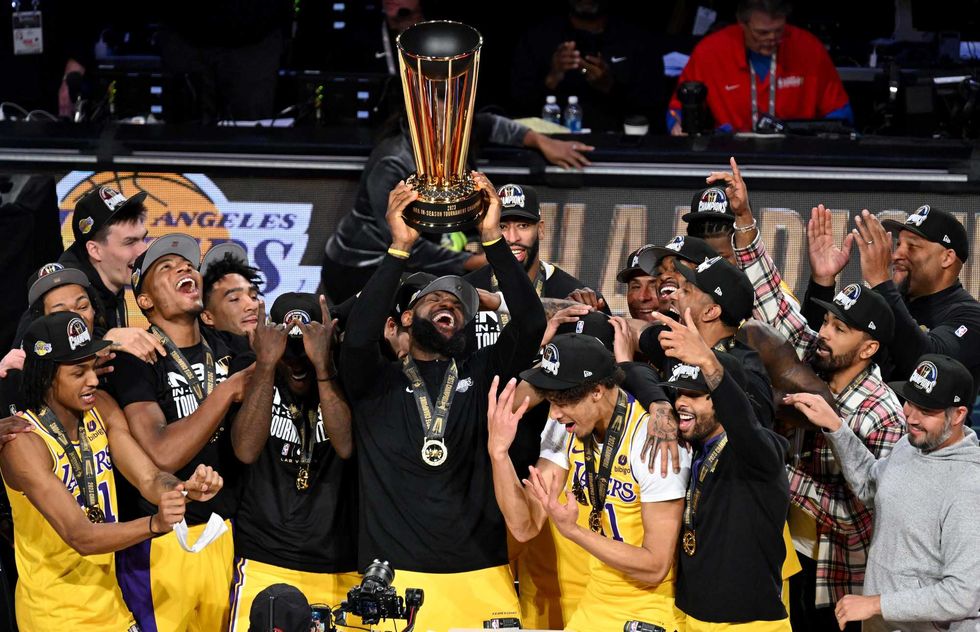 Los Angeles Lakers forward LeBron James (23) hoists the NBA Cup and celebrates with teammates after winning the NBA In-Season Tournament Championship game against the Indiana Pacers at T-Mobile Arena.