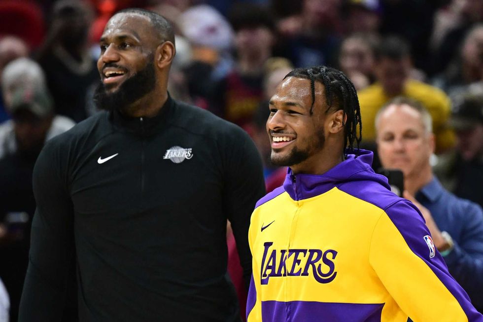 Los Angeles Lakers guard Bronny James, right, and forward LeBron James warm up before the game between the Cleveland Cavaliers and the Lakers at Rocket Mortgage FieldHouse.