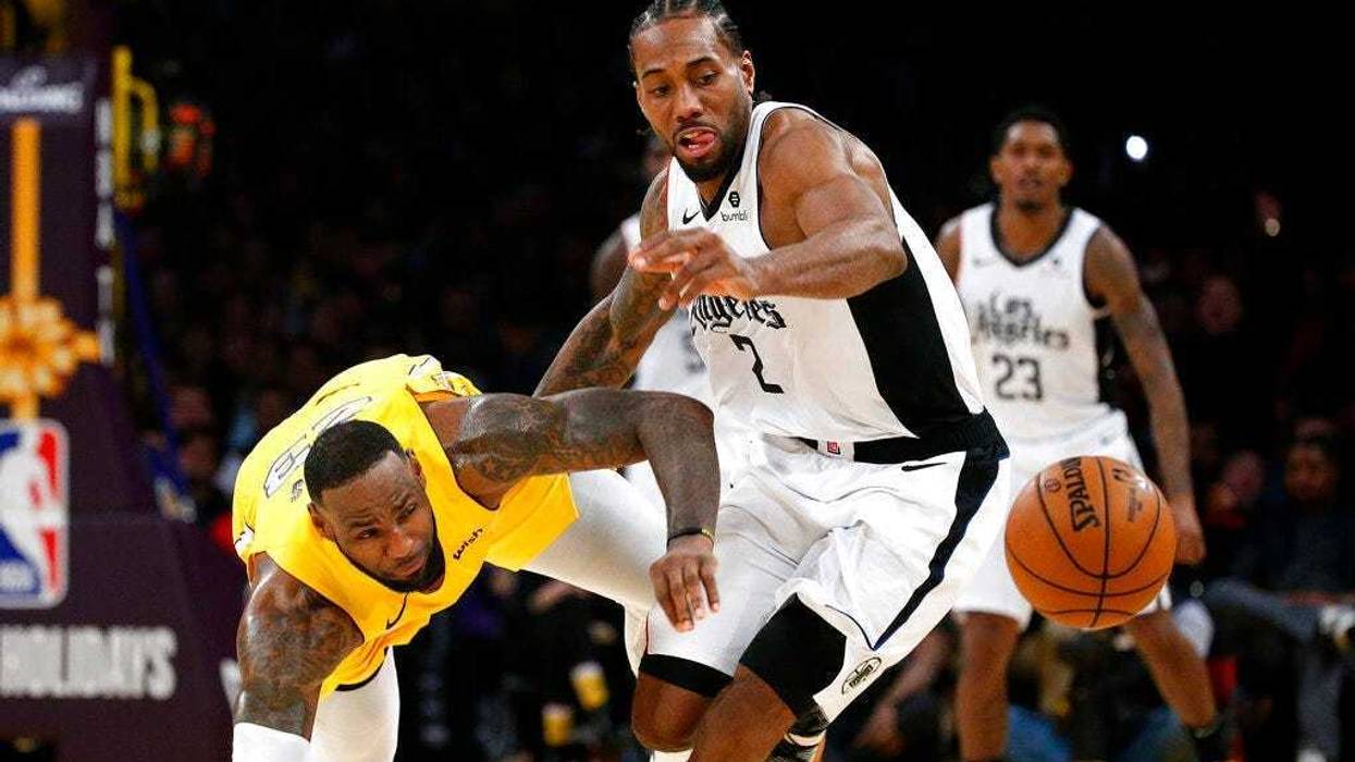 Los Angeles Lakers' LeBron James, left, and Los Angeles Clippers' Kawhi Leonard (2) chase the ball during the second half of an NBA basketball game Wednesday, Dec. 25, 2019, in Los Angeles. The Clippers won 111-106.