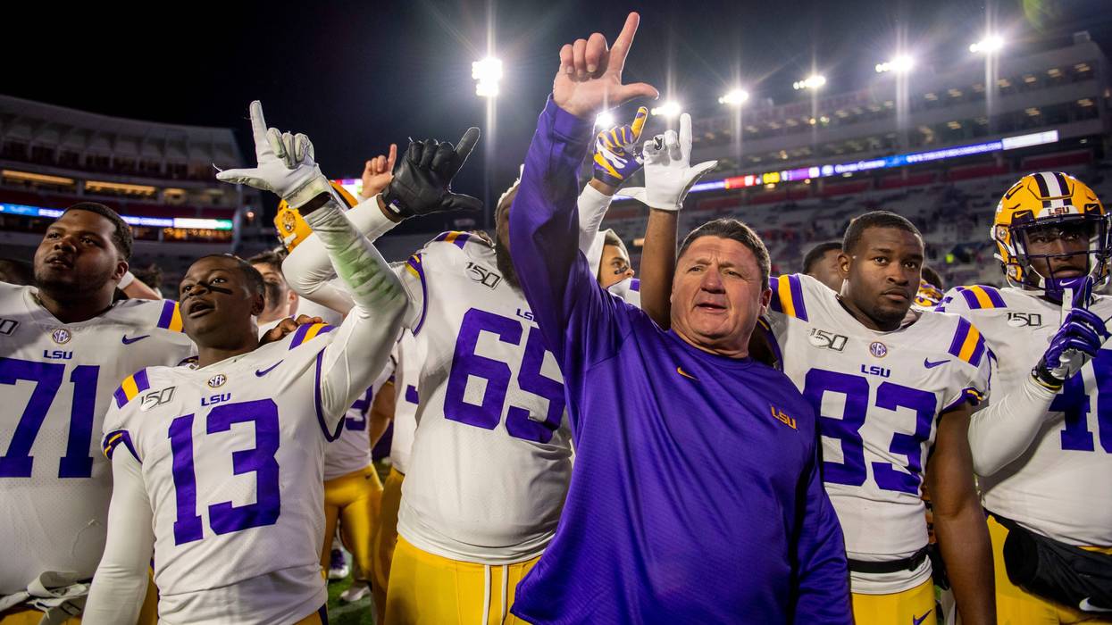 ; Louisiana State Tigers head coach Ed Orgeron hoists the L saluting the band after the game against the Mississippi Rebels at Vaught-Hemingway Stadium.