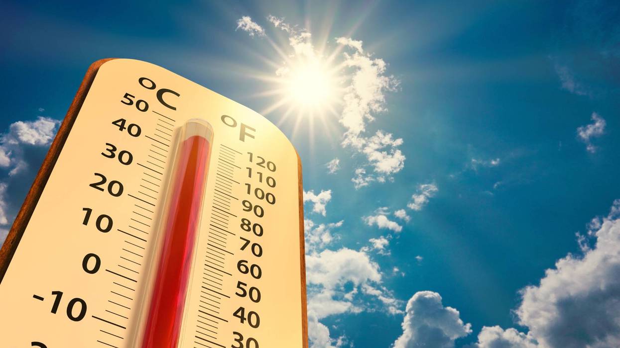 low angle view Thermometer on blue sky with sun shining