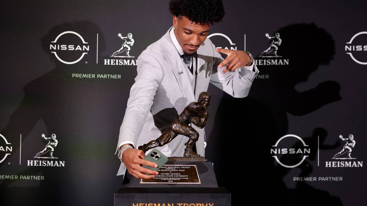 LSU Tigers quarterback Jayden Daniels takes a selfie with the Heisman trophy