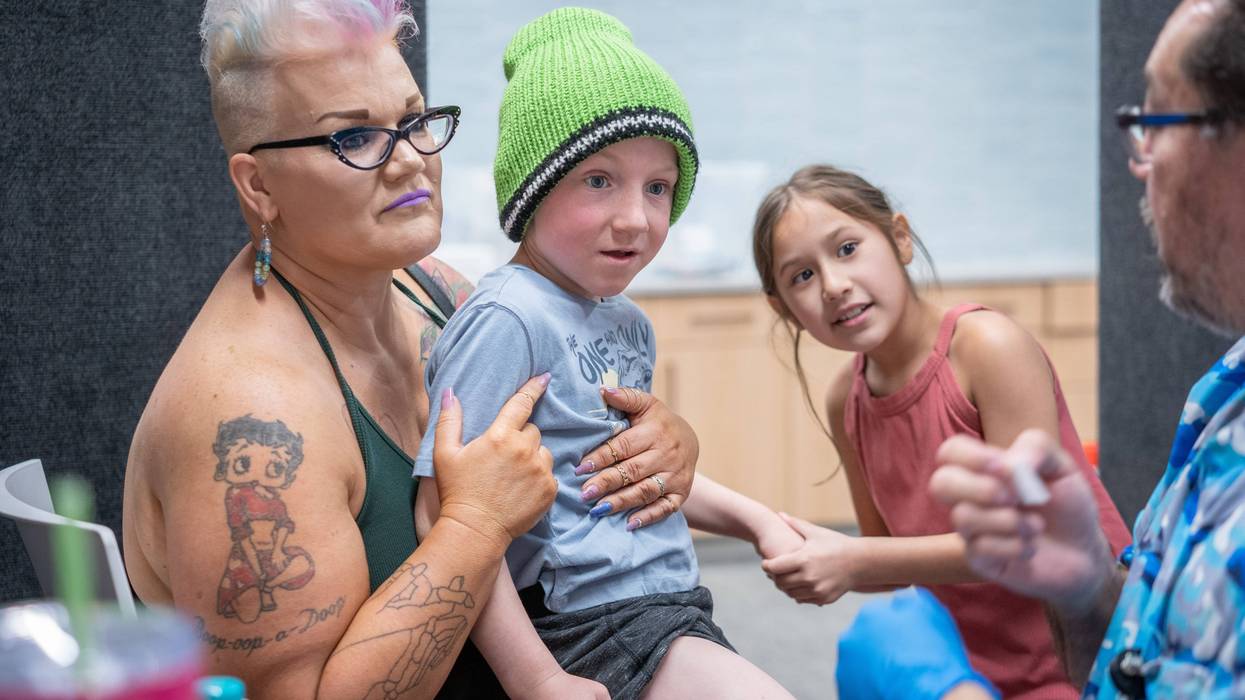 LUBBOCK, TEXAS - MARCH 01: Ambra Hawksley holds her son Andrik Hawksley, age 6, while his sister JaeLynn holds his hand as he prepares to get an MMR vaccine from Raynard Covarrubio, at a vaccine clinic put on by Lubbock Public Health Department on March 1, 2025 in Lubbock, Texas. Cases of Measles are on the rise in West Texas as over 150 confirmed case have been seen with one confirmed death.(Photo by Jan Sonnenmair/Getty Images)