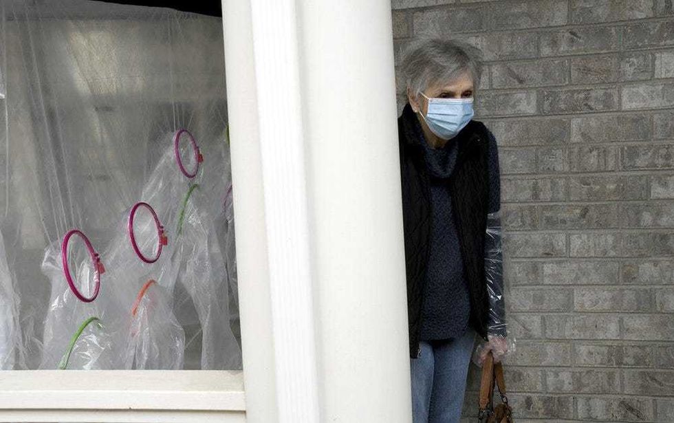 Lynda Hartman, 75, leaves after visiting her 77-year-old husband, Len Hartman, who suffers from dementia at a "hug tent" set up outside the Juniper Village assisted living center in Louisville, Colo., Wednesday, Feb. 3, 2021. The tent includes a construction-grade plastic barrier with built-in plastic sleeves to prevent the spread of the coronavirus. He has been living at the center for about a year, and the couple had not had any physical contact for at least eight months.