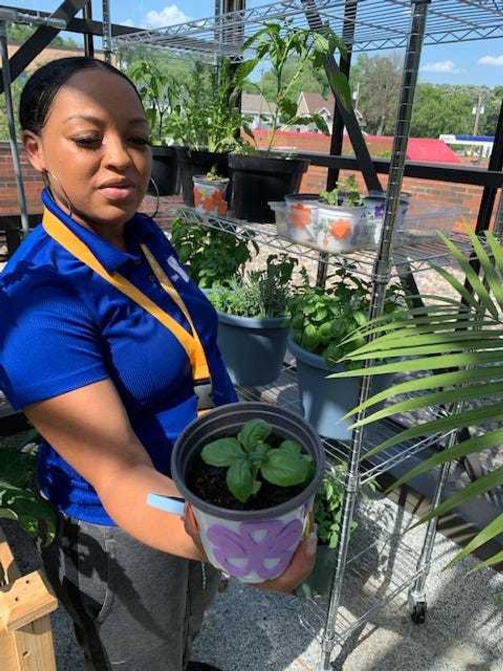 Lyntrell Dickson shows pot, planted by one of her students