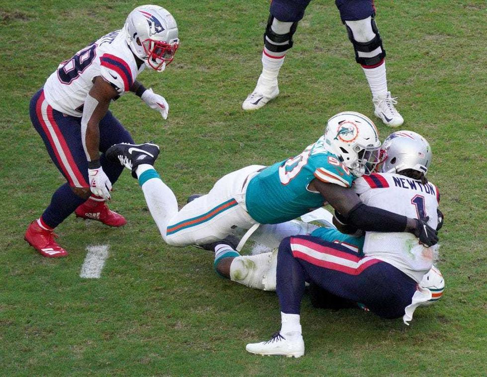 m Newton of the New England Patriots is sacked by Jerome Baker and Shaq Lawson of the Miami Dolphins during the fourth quarter in the game at Hard Rock Stadium on December 20, 2020 in Miami Gardens, Florida.
