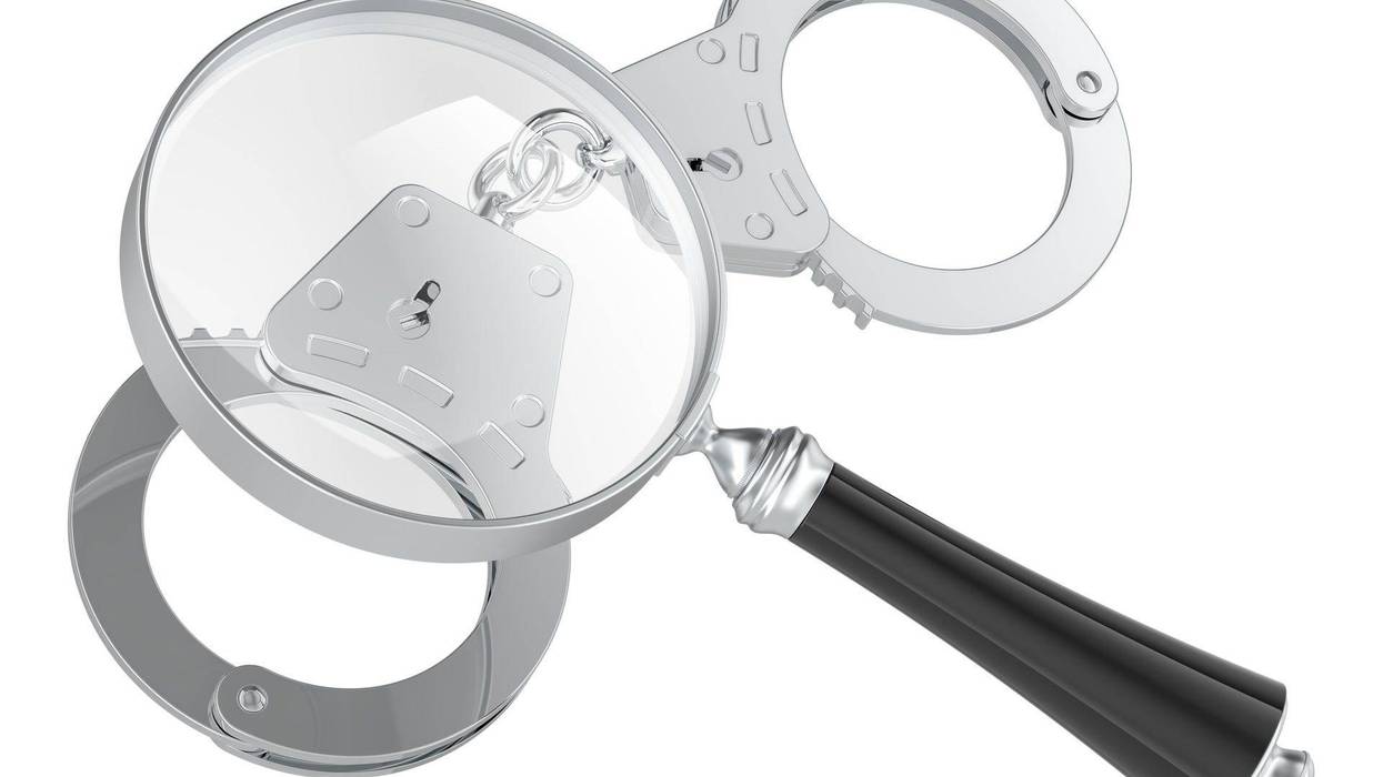 Magnifying glass with handcuffs, 3D rendering - stock photo