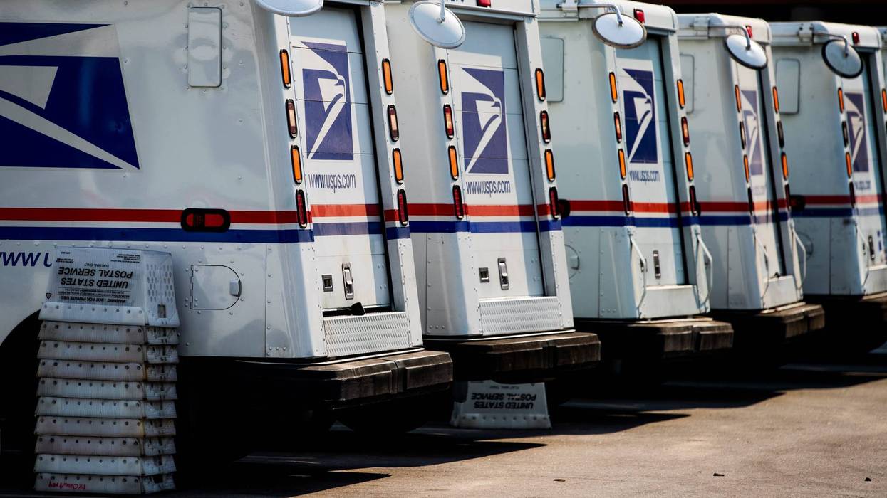 Mail trucks are lined up at a post office