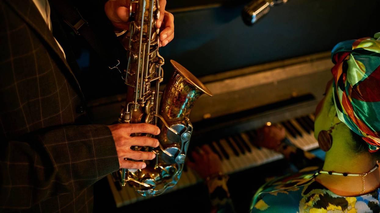 Male Saxophonist Playing Music while Accompanying Piano in Jazz Club