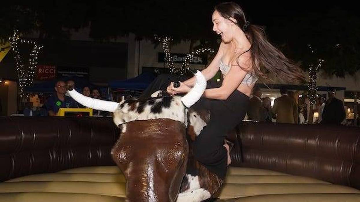 Malia Hui rides a mechanical bull during a New Year's Eve Block Party and Pineapple Drop in downtown Sarasota on Saturday evening