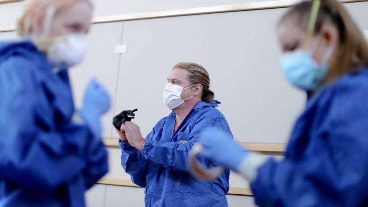 MALIBU, CALIFORNIA - APRIL 08: Volunteers (L to R) Eva Grout, Richard Garvey and Jennifer Niebergall suit up in personal protective equipment (PPE) before conducting drive-through coronavirus testing at Malibu City Hall on April 8, 2020 in Malibu, Califor