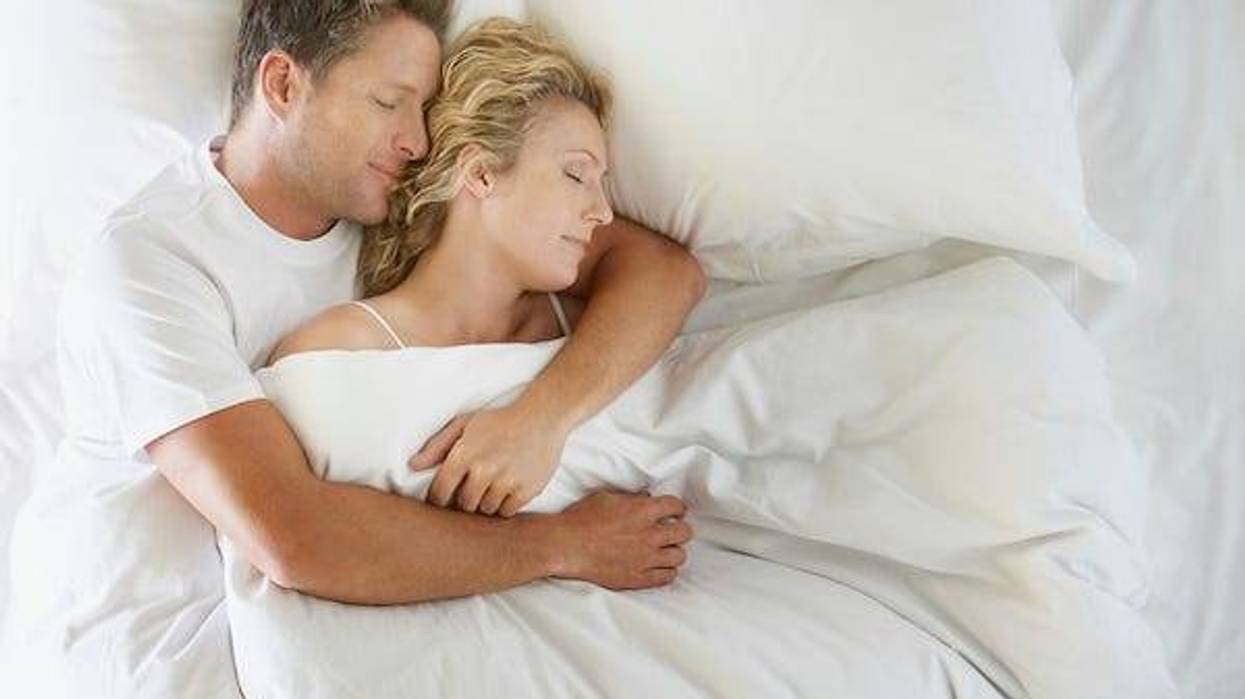Man and woman cuddling in bed